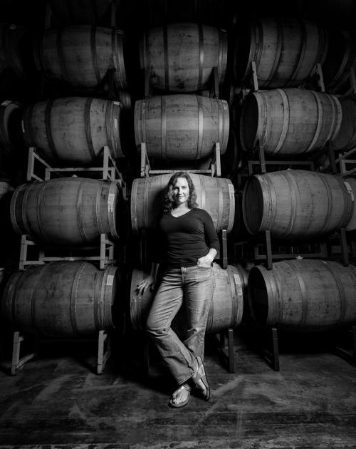 Winemaker Megan standing with barrels in black and white Winemaker Megan standing with barrels in black and white
