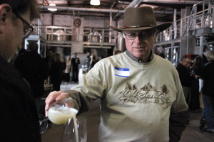 Louis Lucas pours a tank sample of a white wine for visitors